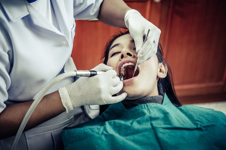 Dentist treating a patient's tooth during an emergency dental visit at Renova Dental