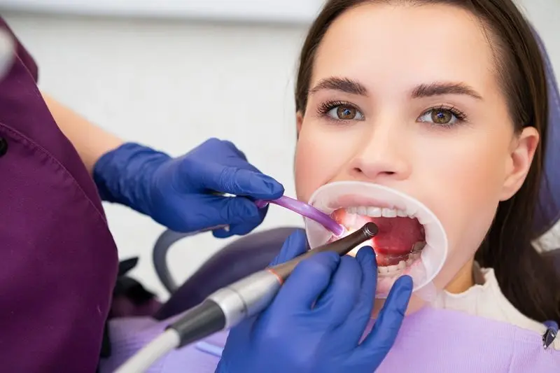 Patient having her teeth and gums checked at a dental visit, where the effects of dry mouth often show up first